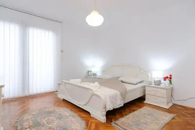 a white bedroom with a white bed and a rug at The Cosmic Gate Apartments in Visoko