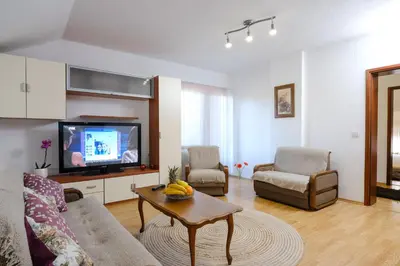 a living room with a couch and a tv at The Cosmic Gate Apartments in Visoko