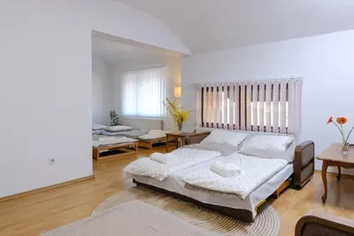 a white room with two beds and a table and chairs at The Cosmic Gate Apartments in Visoko