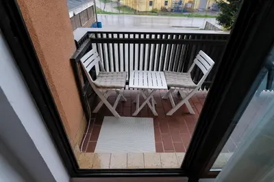 a balcony with two chairs and a table at The Cosmic Gate Apartments in Visoko