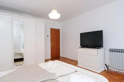a white living room with a tv and a bed at The Cosmic Gate Apartments in Visoko