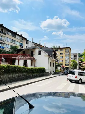 a car is parked on a street with buildings at Apart centar Pliva , Jajce in Jajce