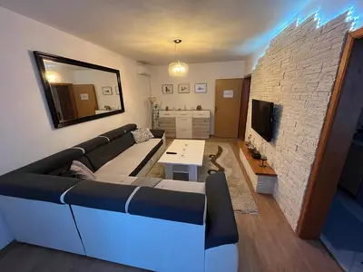 a living room with a couch and a tv at Apartman Harmani in Bihać