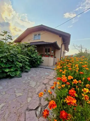 a house with a bunch of flowers in front of it at Unique Una in Ripač