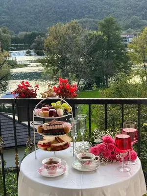 a table with a plate of food on a balcony at Unique Una in Ripač