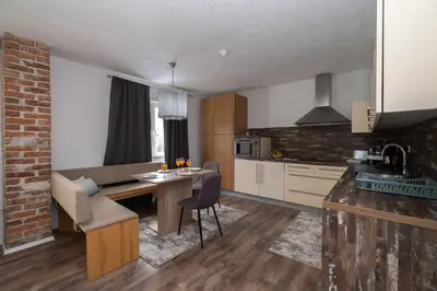 a kitchen and living room with a table and chairs at Greenoasis Bihac in Bihać