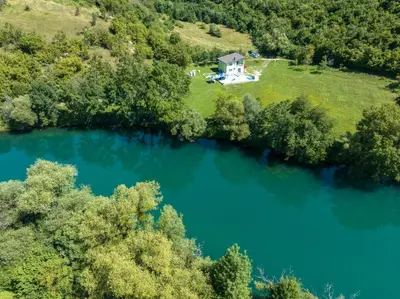 an aerial view of a lake with a house at Greenoasis Bihac in Bihać