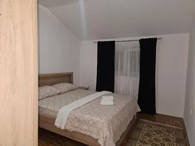 a bedroom with a bed and a window with black curtains at Meri in Jajce