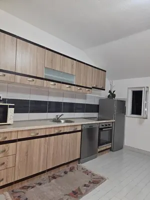 a kitchen with wooden cabinets and stainless steel appliances at Meri in Jajce