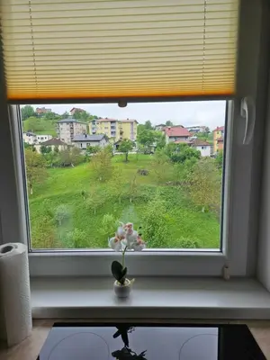 a window with a flower in a vase on a table at Golden Sky in Cazin