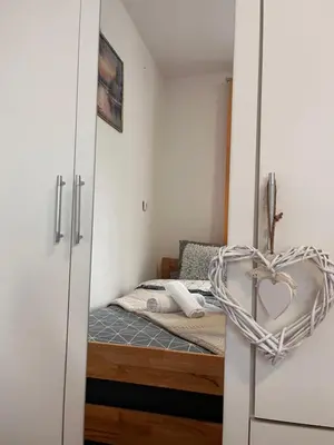 a small bedroom with a bed and a heart basket at Vito apartments in Jajce