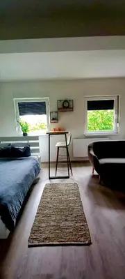 a bedroom with a bed and a table and a couch at Apartman Jakša in Prijedor