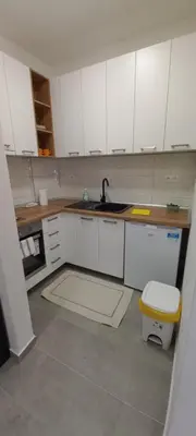 a kitchen with white cabinets and a sink at Apartman Jakša in Prijedor