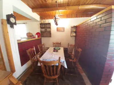 a dining room with a table and chairs and a brick wall at Vikendica odmor za dusu in Visoko
